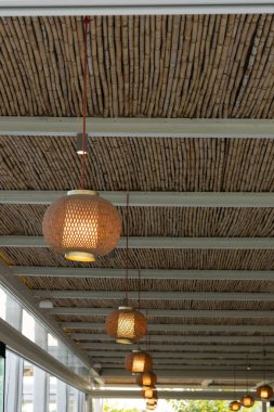 View of wooden lanterns hanging from a bamboo ceiling