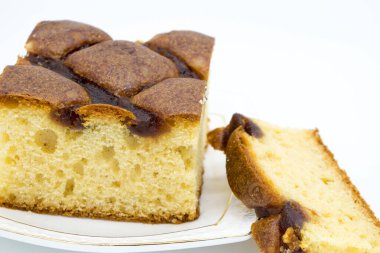 Beyaz arka planda beyaz bir tabakta reçelli şenlikli pasta.