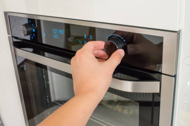 Fırının sıcaklığını değiştiren bir erkeğin görüntüsü