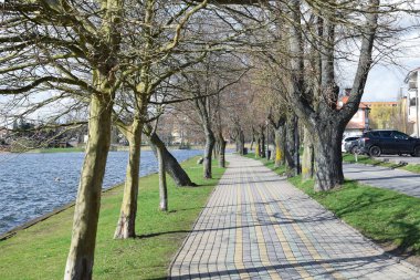 Göl, göl kıyısında yürüyüş yolu güneşli bir bahar sabahı.