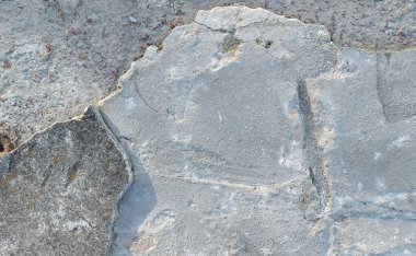 Düz olmayan gri beton çatlak yüzey, üst görünüm dokusu. İğrenç kentsel duvar dokusu. Eski bina yüzeyi tırmalamış, endüstriyel geçmişi zarar görmüş.