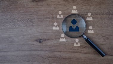 İnsan Kaynakları Yönetimi, HRM. İnsan gelişimi için personel geliştirme ikonları arasında büyüteç odak noktası işe alım liderliği ve müşteri hedef grubu, örnek arama, iyi bir iş adayı bulan personel.