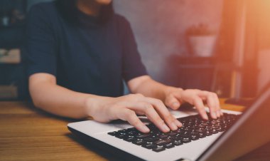 Serbest çalışan, klavyesini yazan, bilgisayarını kontrol eden. Ev ofisinin masaüstü kapalı işyerinde çalışıyor. Çevrimiçi ağ, siber alan, sosyal ve pazarlama taraması kullanan iletişim teknolojisi.