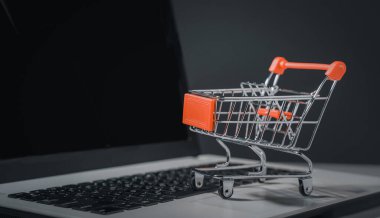 İnternetten alışveriş. Trolley dizüstü bilgisayarda klavyede. Perakende satış mağazası çevrimiçi pazarlama. Nakliye teknolojisi, sipariş kontrol sitesi, ev teslimatı paketi, e-ticaret müşterisi alımı.