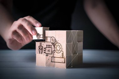 İş adamı ahşap masa ve bulanık arka plan üzerine ahşap blok inşa etmeye çalışır, organizasyon konsepti. Makine öğrenme simgesi, iot, yapay zeka yazılımı, gelecekteki iş dijital teknolojisi 