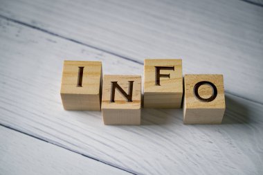Tahta blokta yazılı bilgi kelimesi. Bilgi metni masada. Gri bir masanın parlak yüzeyindeki harf bilgilerini içeren dört tahta blok. Konsept iş stratejisi, yardım masası, sor düğmesi, cevap sorusu.