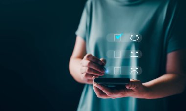 Müşteri hizmetleri ve memnuniyet araştırma konsepti. Hizmette tatmin olmak için sanal ekrana dokunmak. Reyting çok etkileyici. İş kadını müşteri hizmetleri değerlendirmesi için akıllı telefon kullanır.