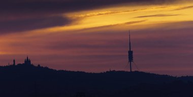 Barcelona siluetiyle Collserola dağ sırasının üzerinde gün doğumu.