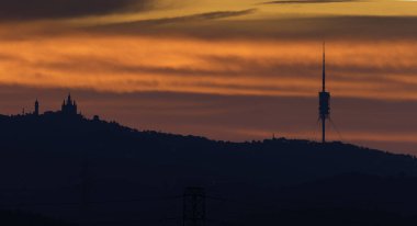 Barcelona siluetiyle Collserola dağ sırasının üzerinde gün doğumu.