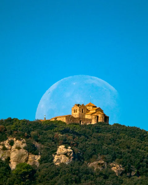 Dolunay batışı, sabah, mavi gökyüzü ile, La Mola dağının üzerinde, Roma tapınağının arkasında.