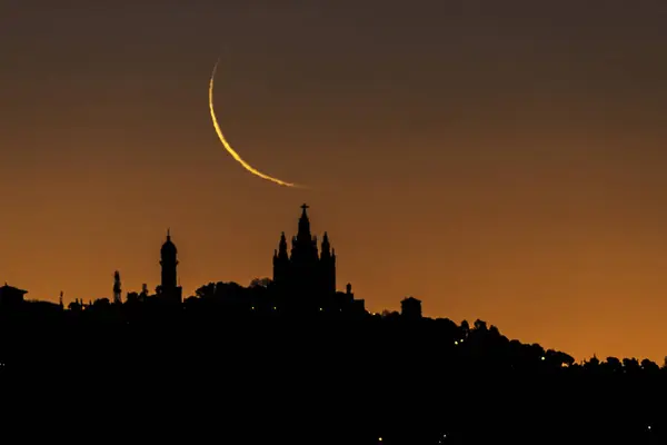 Barcelona 'nın silueti, İsa del Tibidabo' nun Kutsal Yüreği Tapınağı 'nın üzerinde ay yükselişi. Hilal aşaması yüzde 3 'te..