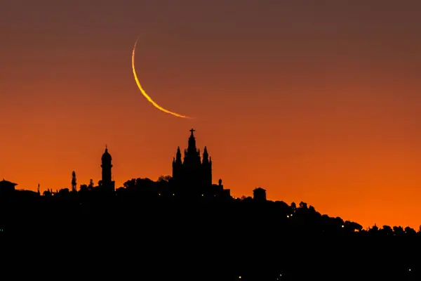 Barcelona 'nın silueti, İsa del Tibidabo' nun Kutsal Yüreği Tapınağı 'nın üzerinde ay yükselişi. Hilal aşaması yüzde 3 'te..