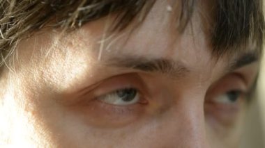 Light gray-blue eye looks up. Human eye close up
