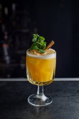 Yellow cocktail with foam on a dark background. Nightlife concept