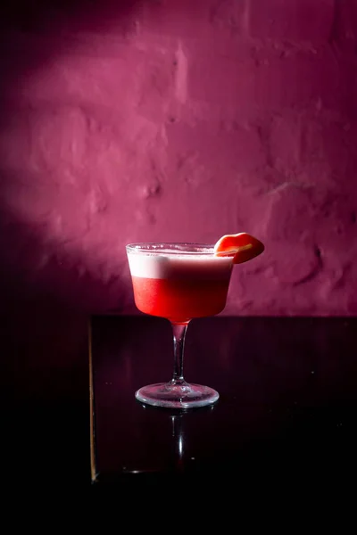 Pink Cocktail on a pink background in the bar. Nightlife concept