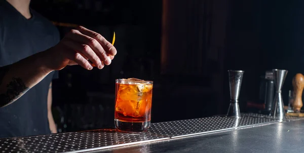 stock image Bartender makes an orange cocktail with citrus fruits. Bar nightlife atmosphere