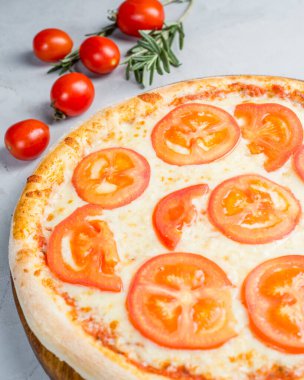 Açık arkaplanda domatesli beyaz peynirli pizza