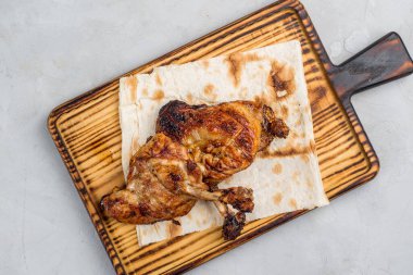 Kesme tahtasında ızgara tavuk bifteği.