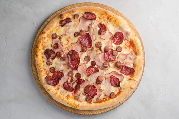 stock image Pizza with vegetables, sausages and ham on a light background