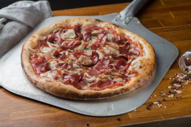 Salamlı, jambonlu, sosisli ve kremalı pizza.