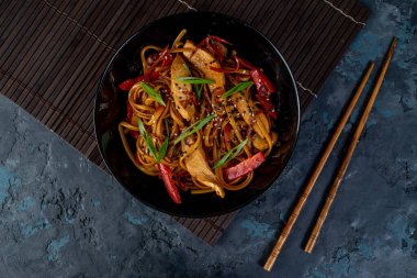 Tavuk ve sebzeli Asya tavuklu erişte ve masada çubuklar. Yukarıdan görüntüle