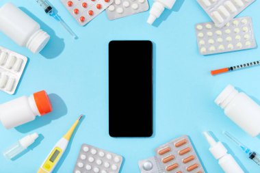 Farklı ilaç hapları ve akıllı telefon. Çevrimiçi uyuşturucu teslimatı konsepti. Sağlık hizmetleri eczanesi ve tıp konsepti.