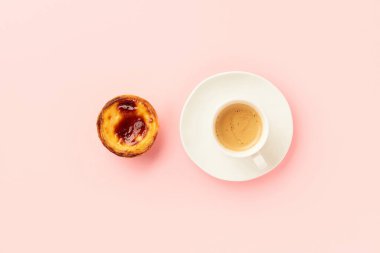 Geleneksel Portekiz yumurtalı tart tatlısı Pasteis Pastel de nata veya Pasteis de Belem, pembe arka planda kahve. Yerel hamur işi kahvaltı konsepti