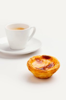 Geleneksel Portekiz yumurtalı tart tatlısı Pasteis Pastel de nata ya da Pasteis de Belem, beyaz arkaplanlı kahve. Yerel hamur işi kahvaltı konsepti