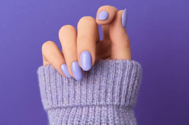 Manikürlü kadınlar menekşe arka planda daha tatlıdır. Manikür, pedikür güzellik salonu konsepti. Metin için boş yer