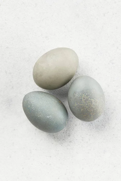 Eggs dyed with natural dyes on a gray background. Easter celebration concept. Greeting card with space for text.