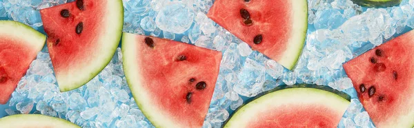 Summer creative wallpaper. Watermelon pattern with sunlight. Sliced fruit with ice on blue background. Flat lay top view.