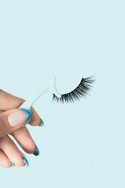 Frauenhände Mit Applikatoren Für Falsche Wimpern Auf Blauem Hintergrund Schönheitsbehandlung — Stockfoto
