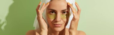 Woman in sunlight with eye patches on pastel green background. Morning skincare routine. Self care beauty treatment concept. clipart