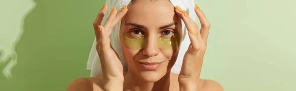 在阳光下的女人 眼上有淡绿色背景的斑斑 早上皮肤护理例程 自理美容疗法概念 图库图片