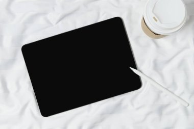 Düz ekran boş ekran dijital tablet beyaz yatakta yatıyordu. Merkez ofis çalışma alanı. İş, çalışma şablonu.