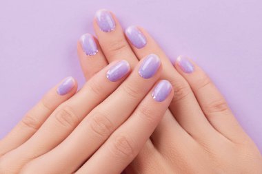 Modaya uygun lavanta manikürlü kadın elleri. Bahar yaz tırnak tasarımı. Moda güzellik salonu konsepti