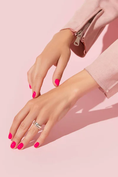 女人的手与粉红色的指甲设计 修指甲 修脚美容院的概念 流行的颜色 深长的阴影 免版税图库图片