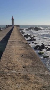 Portekiz 'in Porto şehrindeki Farolim de Felgueiras deniz feneri, Atlantik Okyanusu. Dikey video, 4k