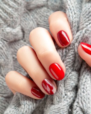 Manikürlü kadınlar el ele örgü örerler. Manikür, pedikür tasarım trendleri. Sevgililer Günü Noel manikürü