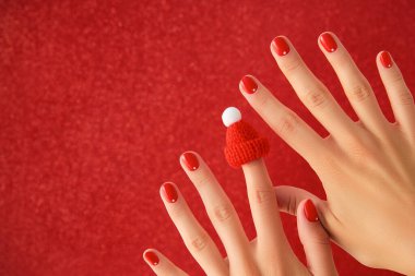 Kırmızı minimalist tırnak tasarımlı kadın elleri. Manikür, pedikür güzellik salonu konsepti. Yeni yıl Noel indirimi