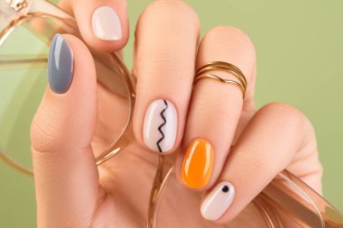 Close up womans hands with trendy minimal manicure on green background. Spring summer nail design. Beauty salon concept. clipart