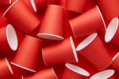 Kırmızı arka planda kağıt bardaklar. Çevre dostu, sürdürülebilir yaşam tarzı. Düz üst görünüm