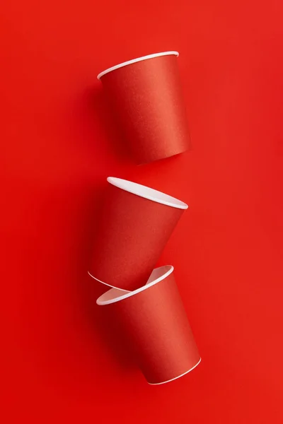 Paper cups on a red background. Eco friendly, sustainable lifestyle. Flat lay top view