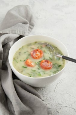 Tipik Portekiz çorbası Caldo Verde gri arka planda, yakın planda. Geleneksel Portekiz mutfağı. Dikey çekim