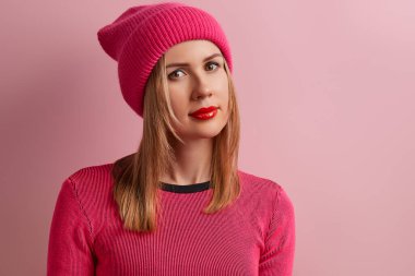 Pembe arka planda kırmızı ruju olan güzel, genç bir kadın. Bahar sonbahar kıyafetleri. Alışveriş satış konsepti