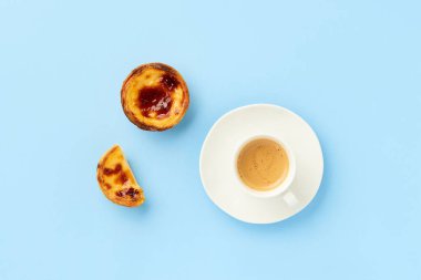 Geleneksel Portekiz yumurtalı tart tatlısı Pasteis Pastel de nata veya Pasteis de Belem, mavi arka planda kahve. Yerel hamur işi kahvaltı konsepti