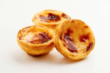 Beyaz arka planda geleneksel Portekiz yumurtalı tart Pasteis Pastel de nata veya Pasteis de Belem. Yerel hamur işi kafeteryası kavramı