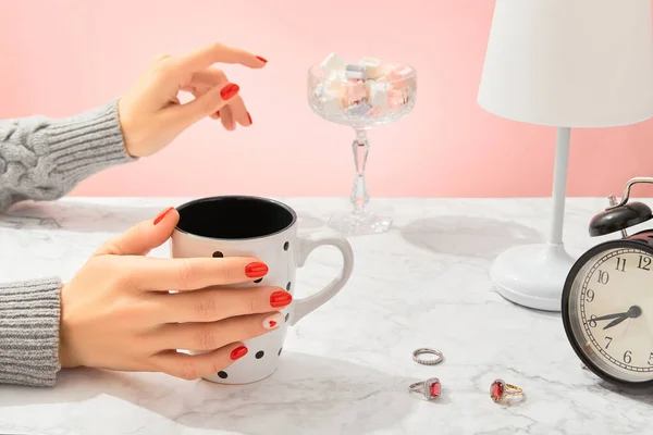 Well-groomed female hands on marble table. Trendy fashion accessories. Valentines day nail design.