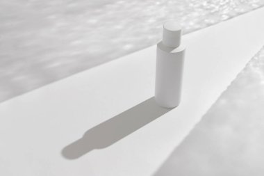 Kıtır beyaz arka planda bir kavanoz kozmetik kremi. Basitliğin büyüleyici zarafetle buluştuğu sanatsal gölgeler. Güzellik tedavi konsepti