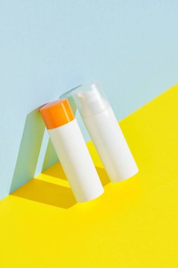 Mavi sarı arkaplanda fotokopi alanı olan güneş kremi. Vücut bakımı güzellik tedavisi konsepti. Yaz tatili